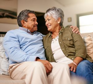 couple sitting on couch happy after their SSDI claim was approved