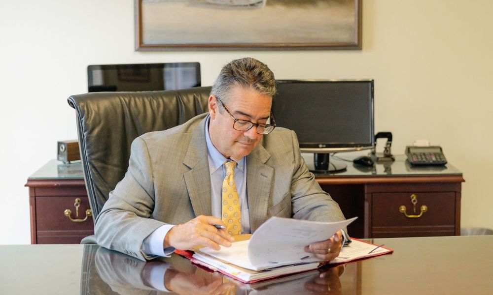 Lance Jackson, social security disability lawyer at Montagna Law reviewing paperwork on a large wooden desk