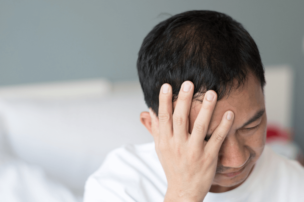 man holding his head looking upset