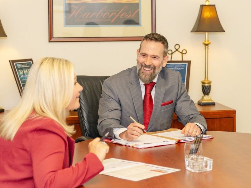 Montagna Law attorneys smiling while reviewing documents after a successful case result