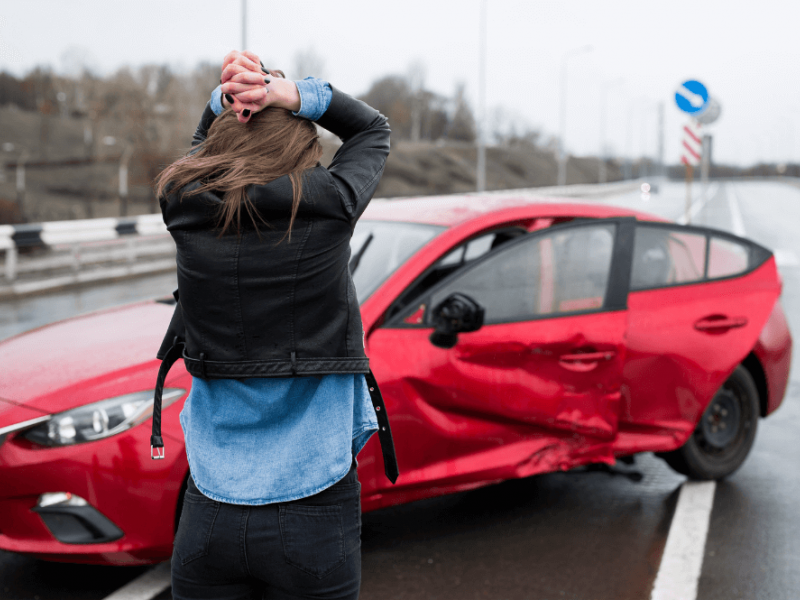 Woman looking at her wrecked car