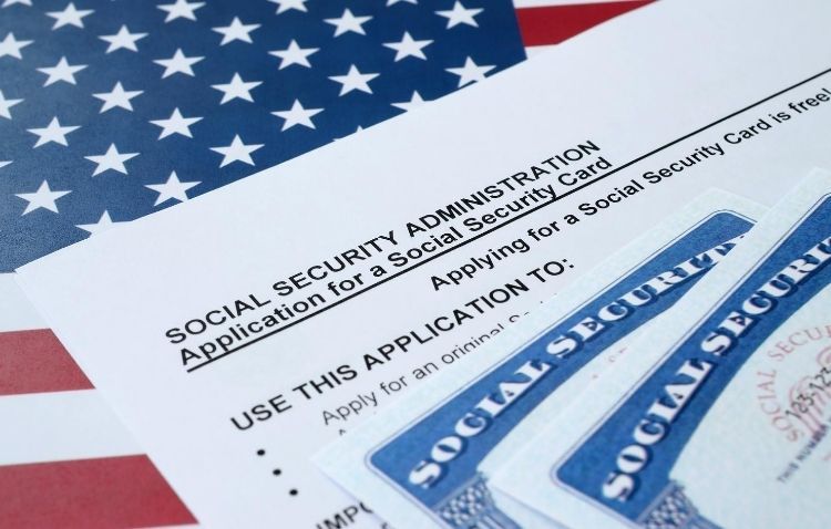 Social Security application with cards on an American flag background, illustrating U.S. identity documentation.