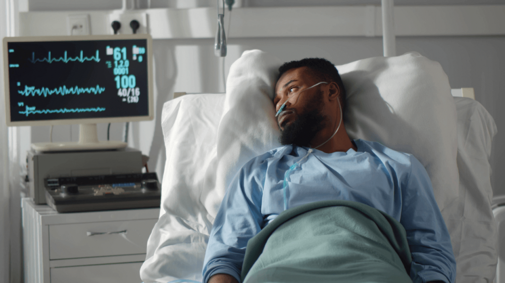Man laying in a hospital bed on life support