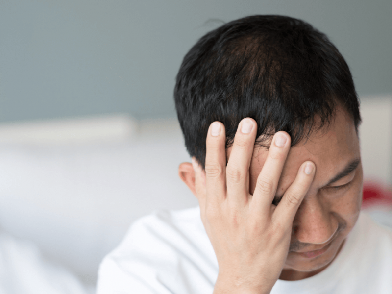 man holding his head looking upset