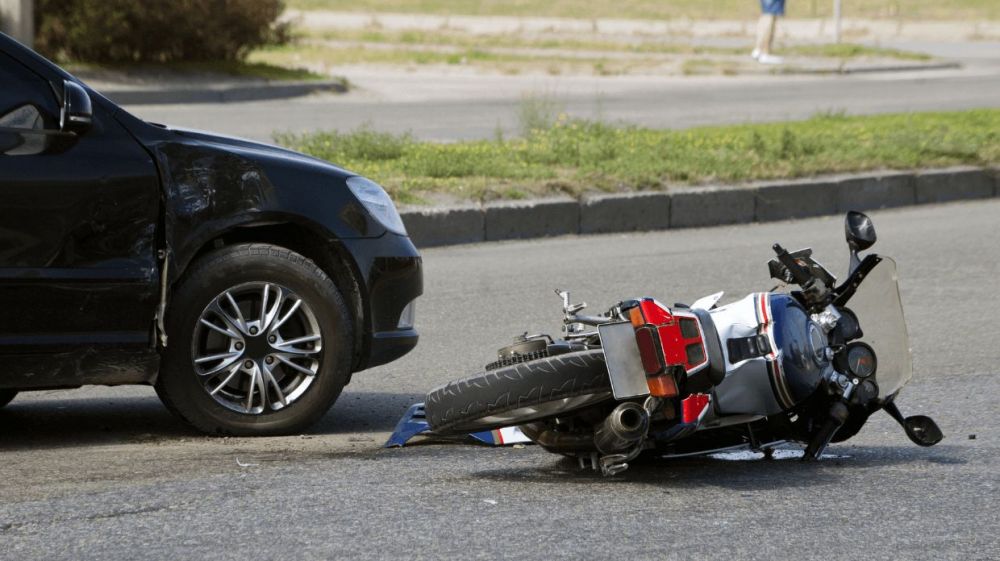 motorcycle on its side after accident with car