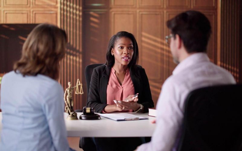 Three women discussing divorce costs at a table