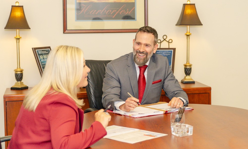 Montagna Law attorneys smiling while reviewing documents after a successful case result