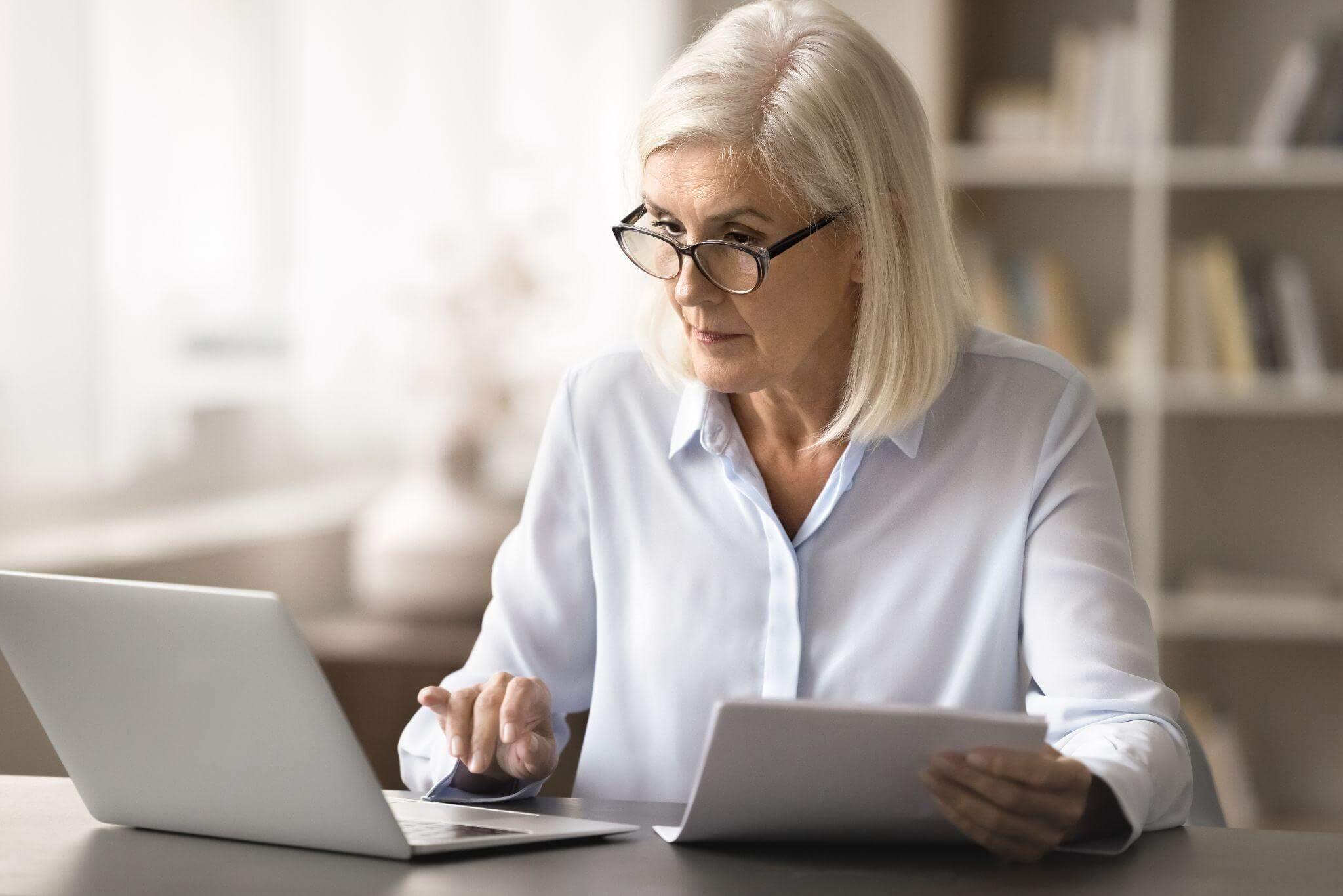 a woman sitting at a table using a laptop computer