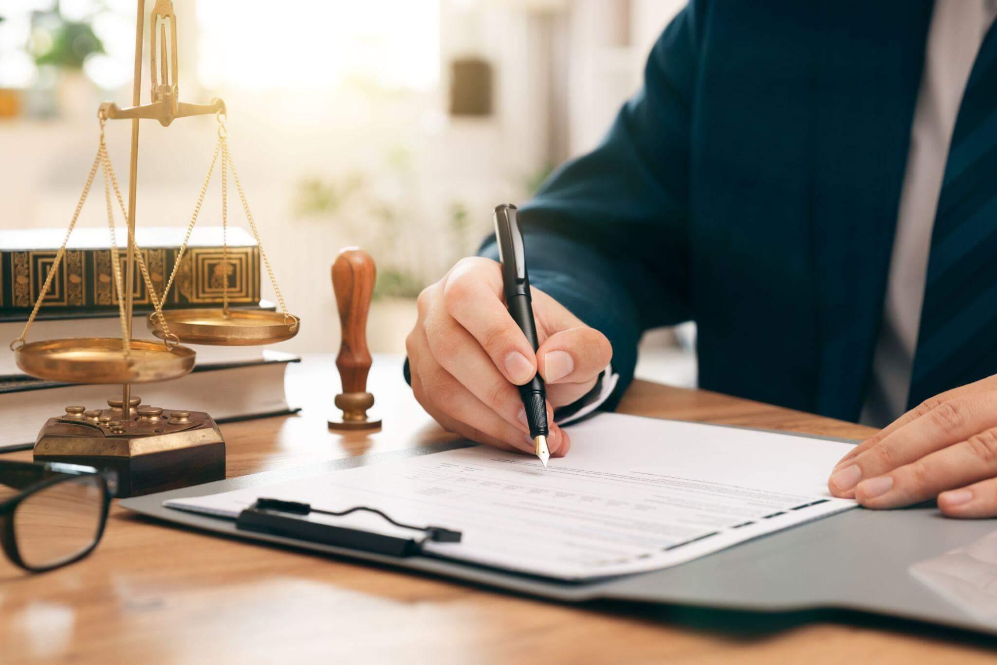 a man sitting at a desk writing on a piece of paper