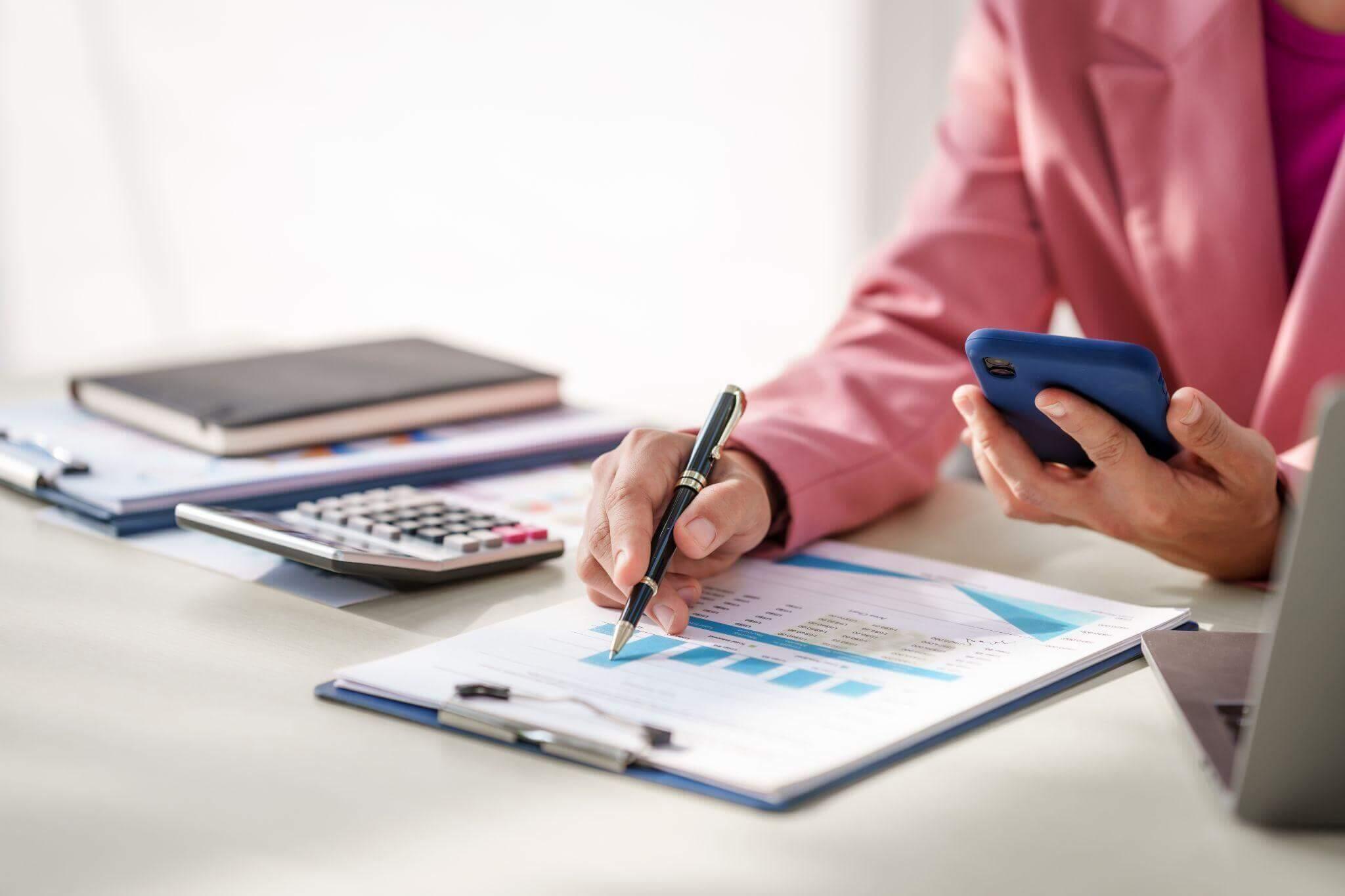 Person planning disability benefits with notebook and phone at table
