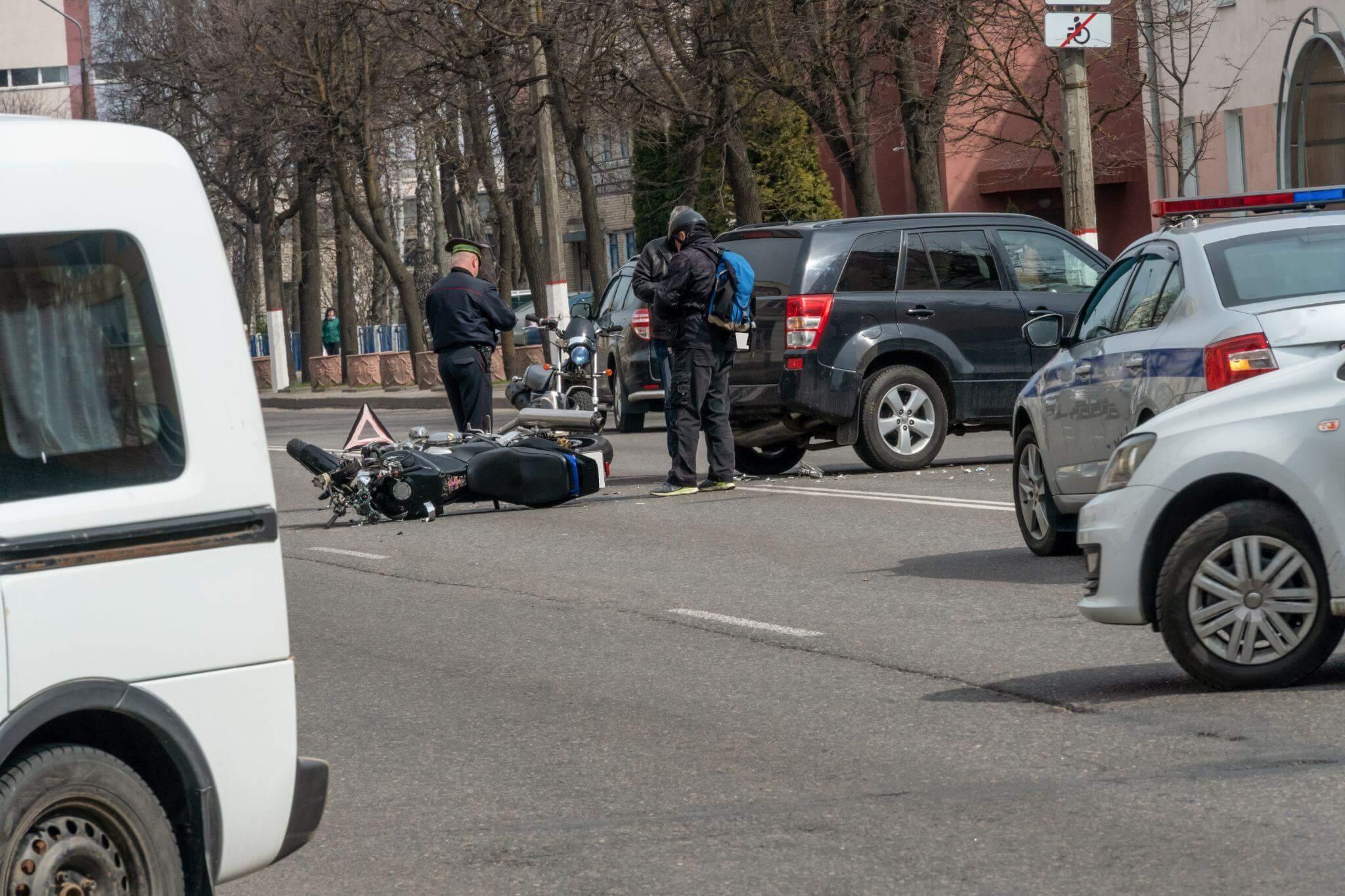 a police officer standing next to a motorcycle on the side of a road
