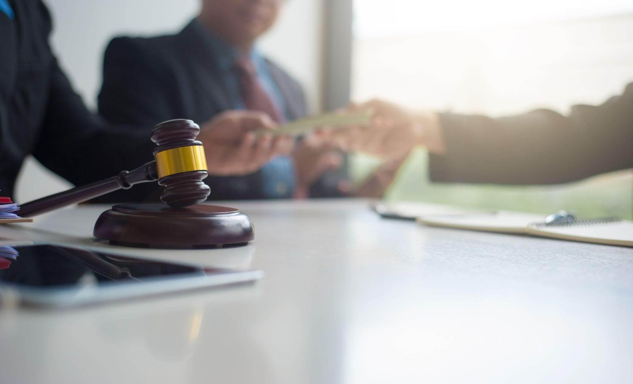 two people shaking hands over a wooden judge
