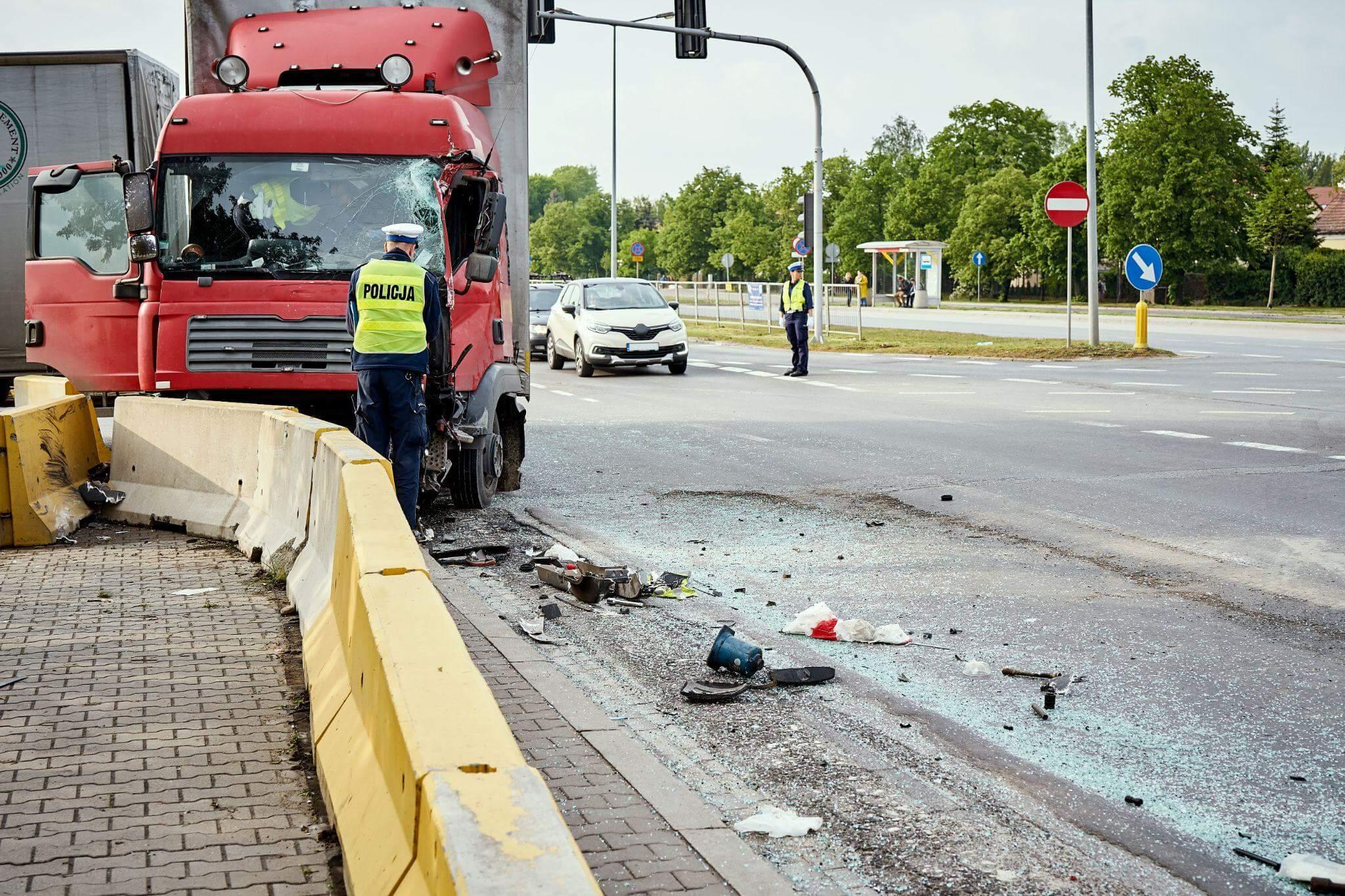 a man standing next to a red truck on a road