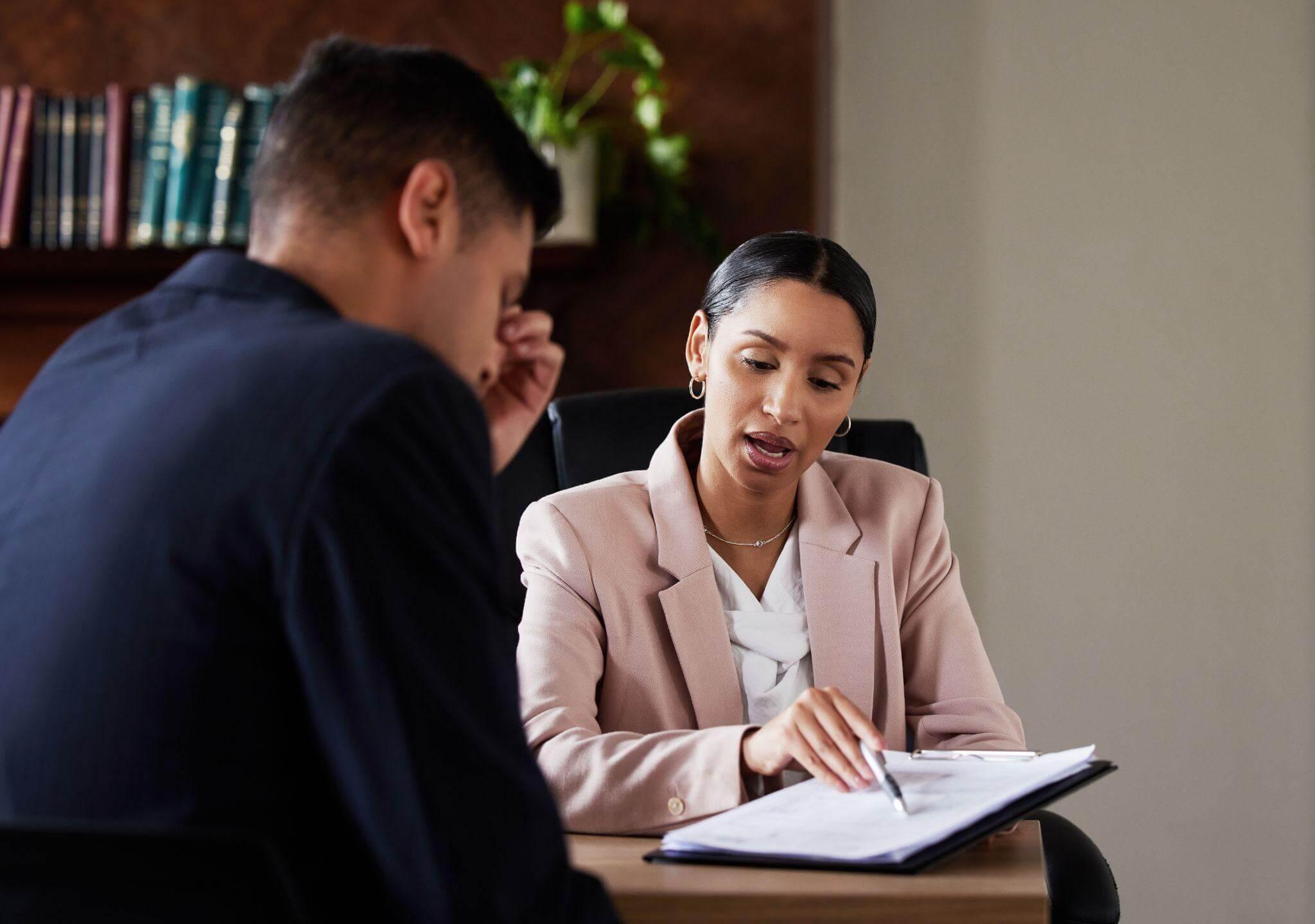 a woman sitting at a desk with a man