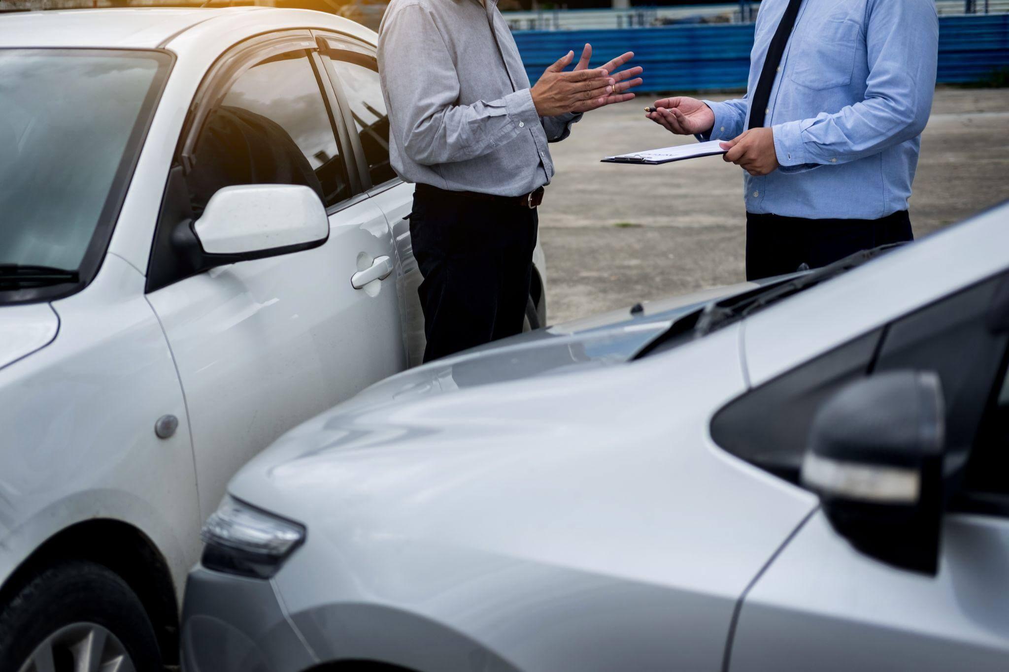 a couple of men standing next to a white car