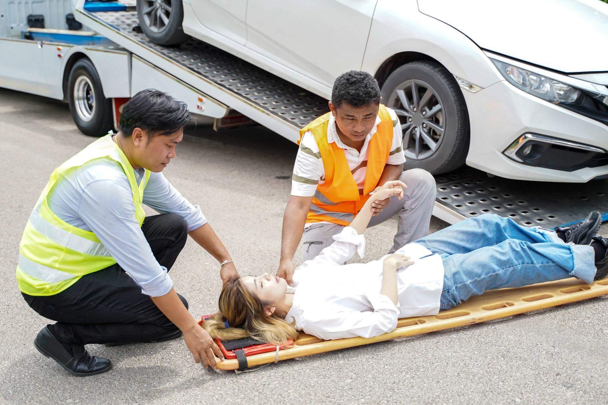 a person on a stretcher being assisted by a person in a safety vest