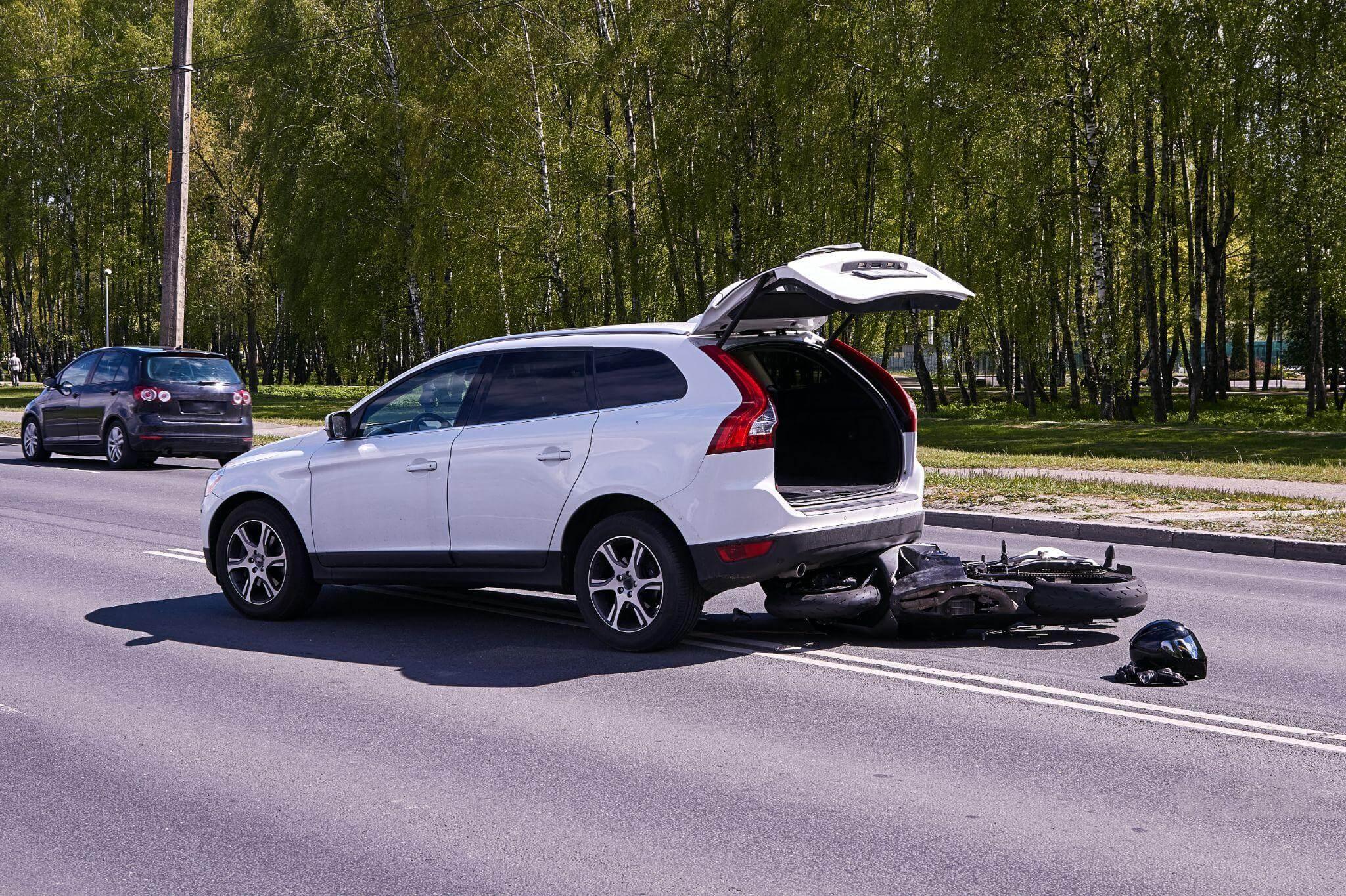 a white car with its trunk open on the side of the road