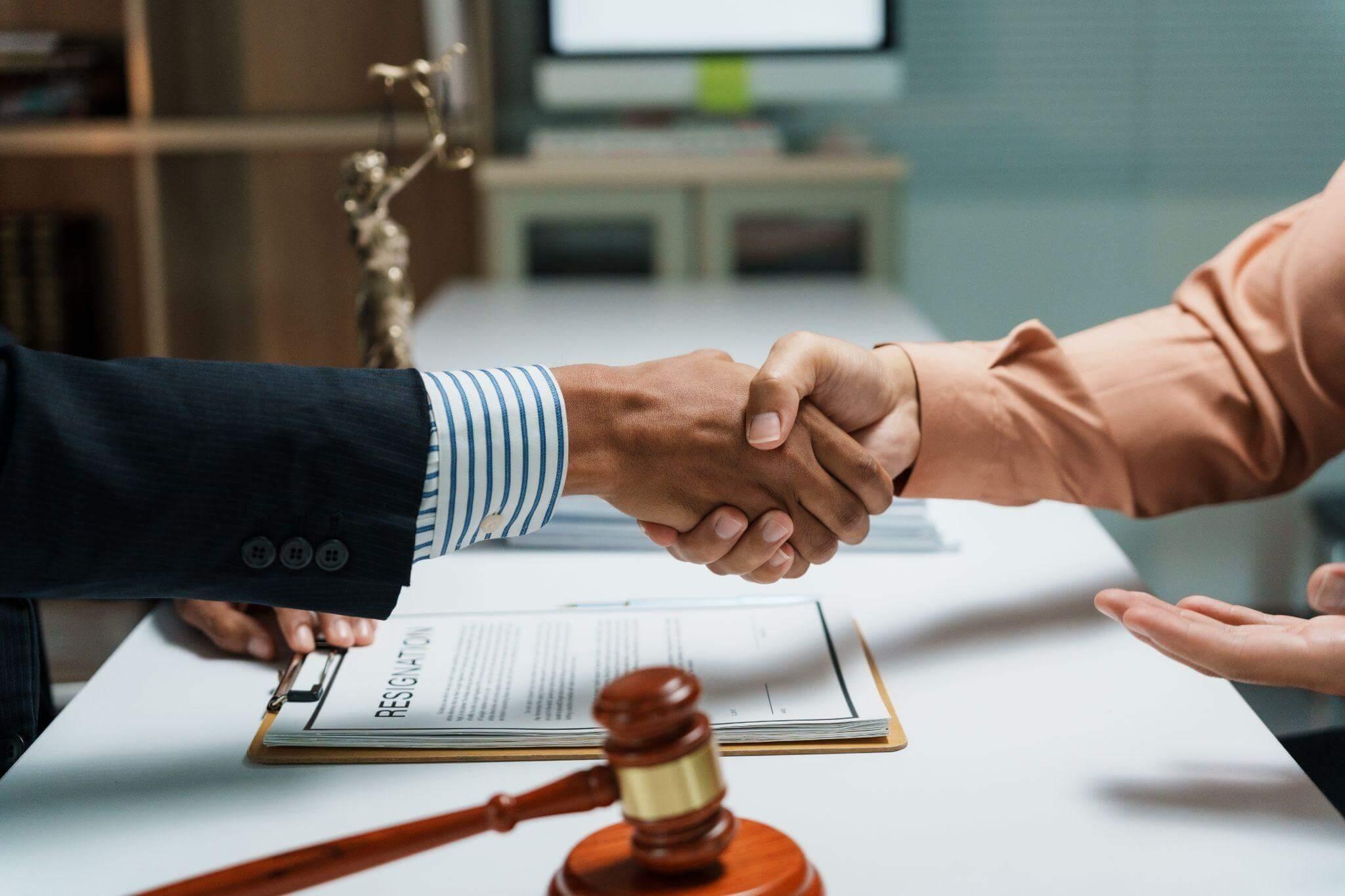 two people shaking hands in front of a judge