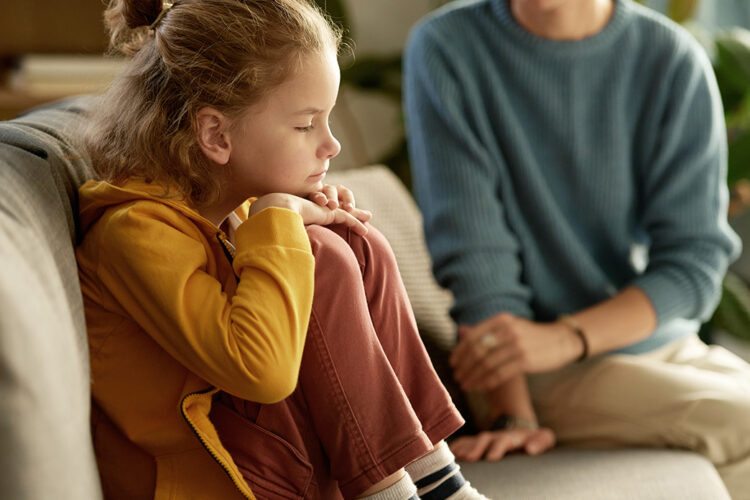 sad-child-on-couch-with-parent-1.jpg