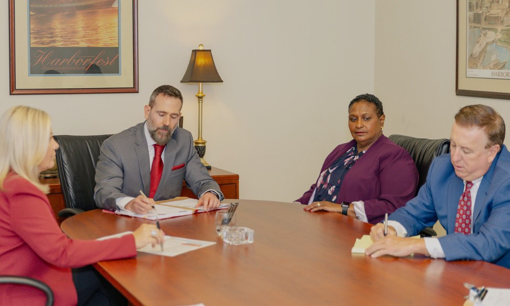 Montagna law attorneys gathered around an office table in Norfolk Virginia