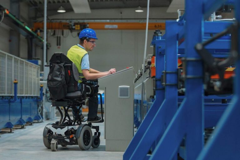 a man in a wheel chair working on a piece of equipment