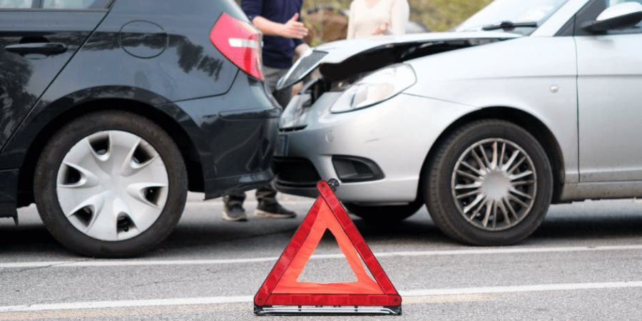 car accident with warning triangle in road and people arguing in background