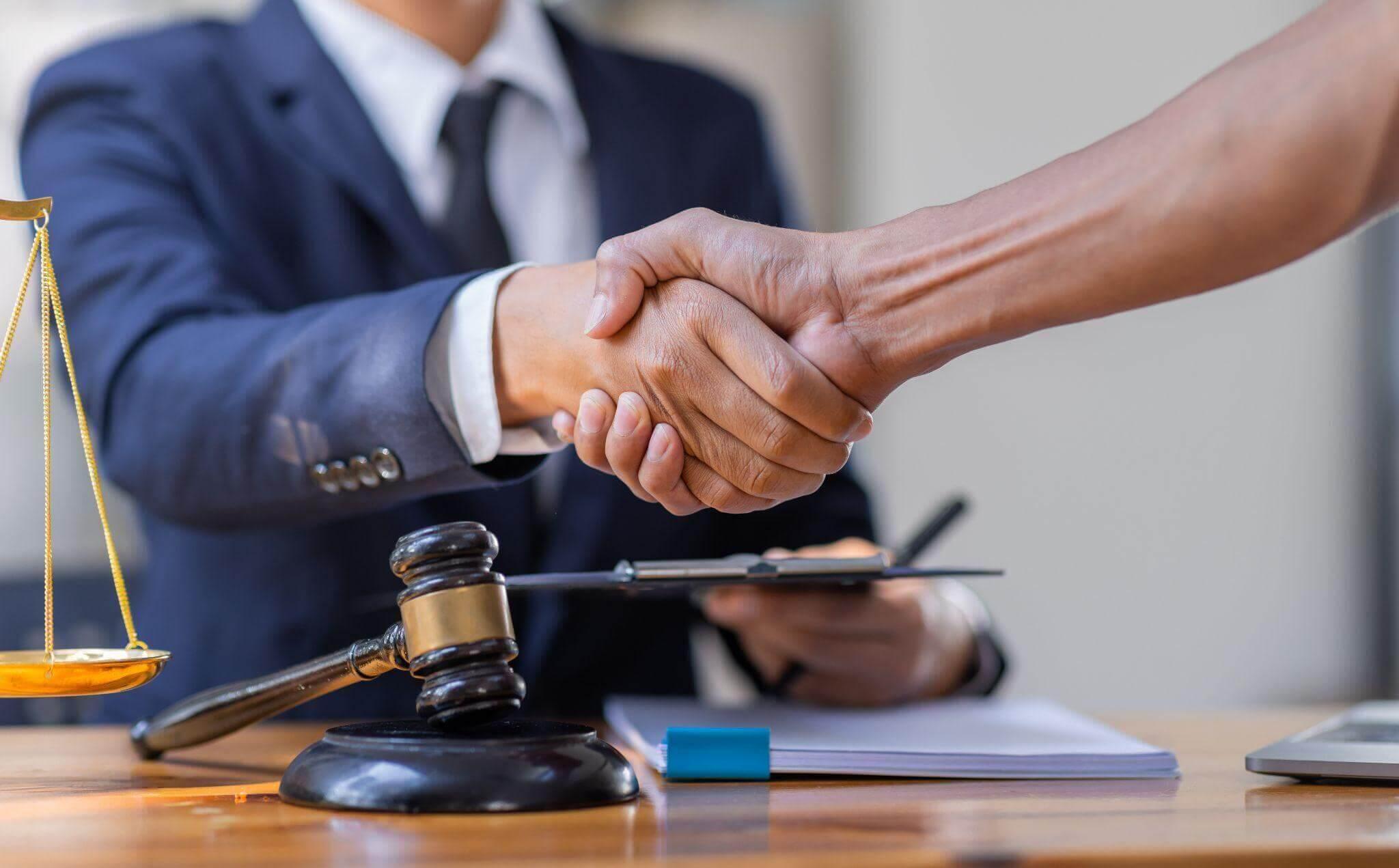 Two people shaking hands in front of justice scale related to social security disability benefits