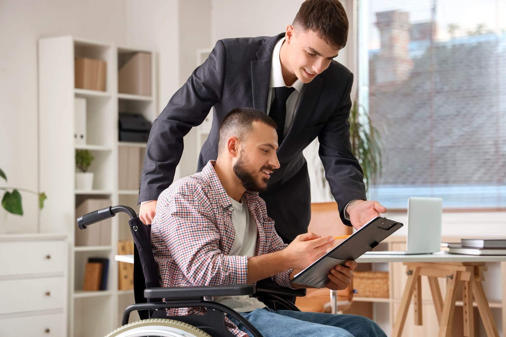Reviewing a denied disability application with a man in wheelchair
